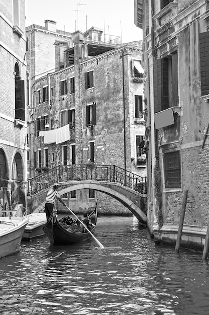 Venetian view with small canal and gondola, venice, italy. black and white