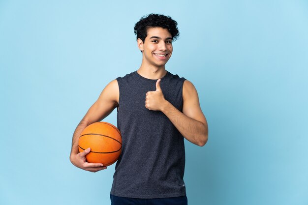 Venezolaanse basketbalspeler man over geïsoleerde muur met een duim omhoog gebaar