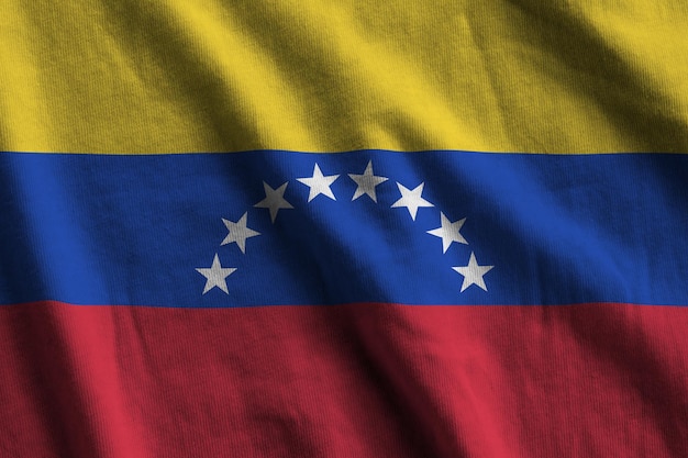 Venezuela flag with big folds waving close up under the studio light indoors The official symbols and colors in banner