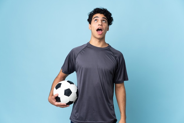 Venezuelan football player man over isolated background looking up and with surprised expression