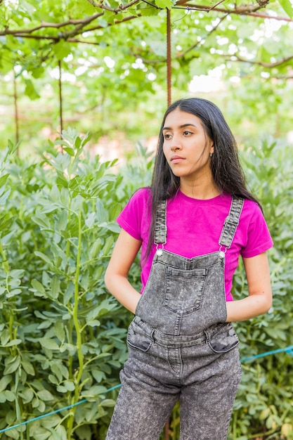 Venezuelan Latin young woman gardening and harvesting in urban garden portrait