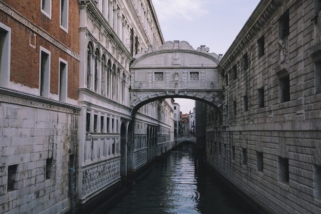 Venice, Italië - 1 juli 2018: Panoramisch uitzicht op de Brug der Zuchten (Ponte dei Sospiri) is een brug in Venetië aan de kust van de stad. Landschap van zomerochtend en dramatische blauwe lucht