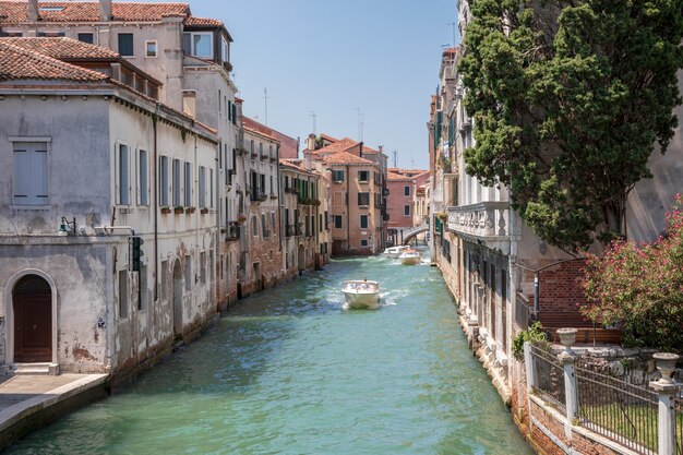 Venice, Italië - 1 juli 2018: Panoramisch uitzicht over het smalle kanaal van Venetië met historische gebouwen en boten vanaf de brug Foscari. Landschap van zonnige zomerdag en blauwe lucht