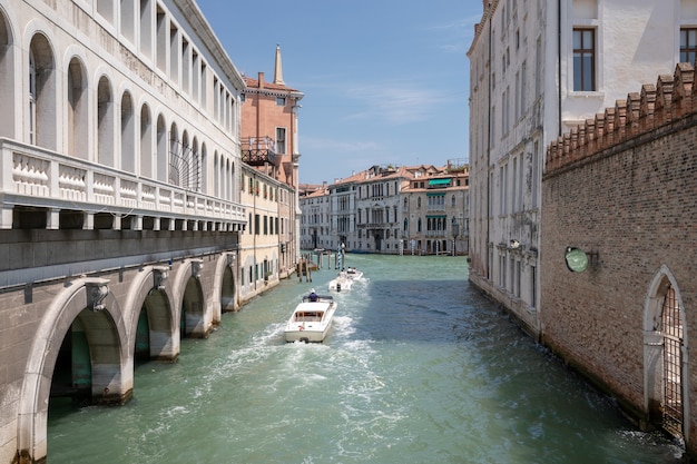 Venice, Italië - 1 juli 2018: Panoramisch uitzicht over het smalle kanaal van Venetië met historische gebouwen en boten vanaf de brug Foscari. Landschap van zonnige zomerdag en blauwe lucht