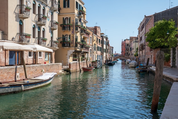 Venice, Italië - 1 juli 2018: Panoramisch uitzicht over het smalle kanaal van Venetië met historische gebouwen en boten vanaf de brug. Landschap van zonnige zomerdag