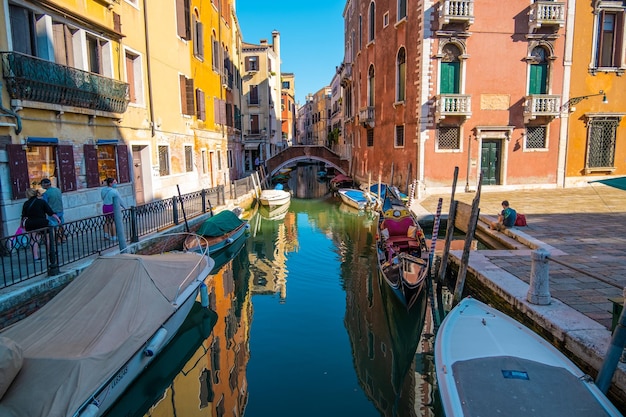 VENICE ITALY August 27 2021 View of empty gondola on narrow canals with a tourist waiting for the gondolier of Venice Italy