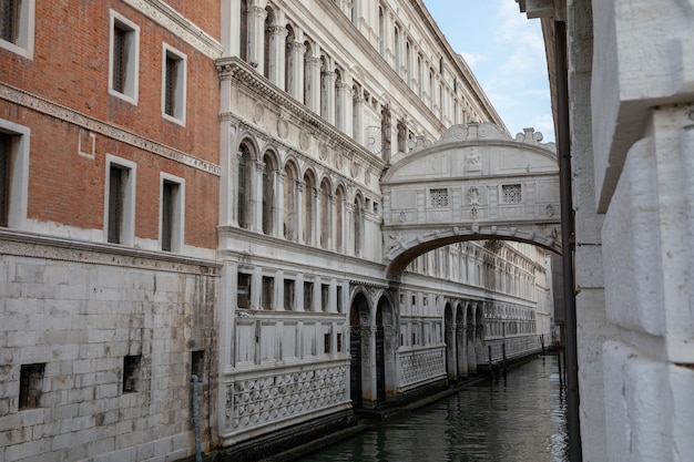 Venice, Italy - July 1, 2018: Panoramic view of Bridge of Sighs (Ponte dei Sospiri) is a bridge located in Venice on coast of city. Landscape of summer morning day and dramatic blue sky