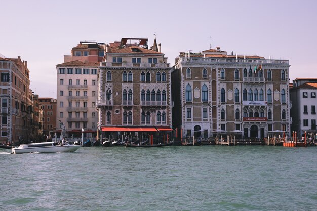 Венеция, Италия - 1 июля 2018: Панорамный вид на Гранд-канал (Canal Grande) с лодками с активным движением. Это главный транспортный коридор Венеции. Пейзаж летнего солнечного дня и голубого неба