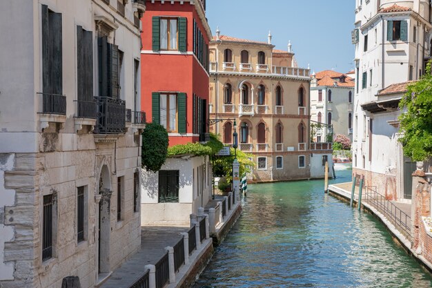 Venice, Italy - July 1, 2018: Panoramic view of Venice narrow canal with historical buildings and boats from bridge. Landscape of summer sunny day