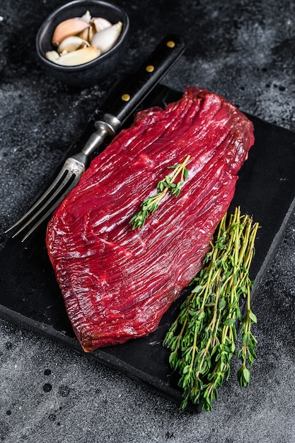 野生の肉からの鹿肉の生ステーキ。黒の背景。上面図。