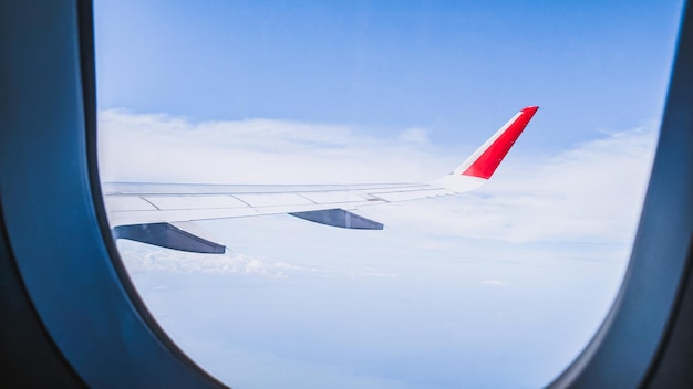 Venster naar de wereld een blik van bovenaf wolken in het vliegtuig reizen in de lucht