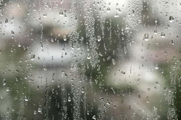 Vensterglas met regendruppels als achtergrond close-up