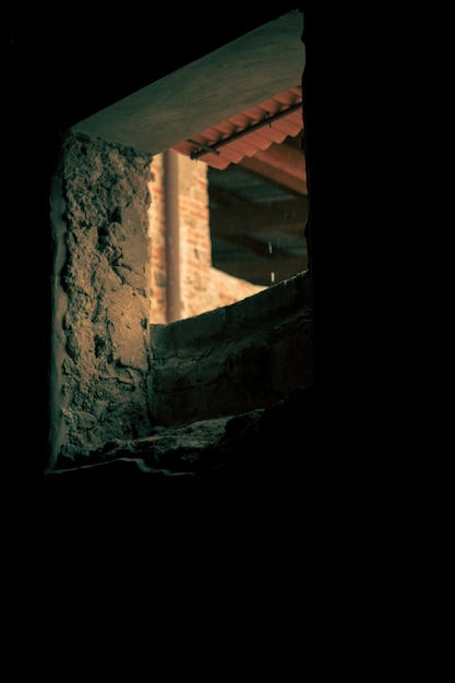 Foto ventana hacia el exterieur en una habitacion oscura en napoles