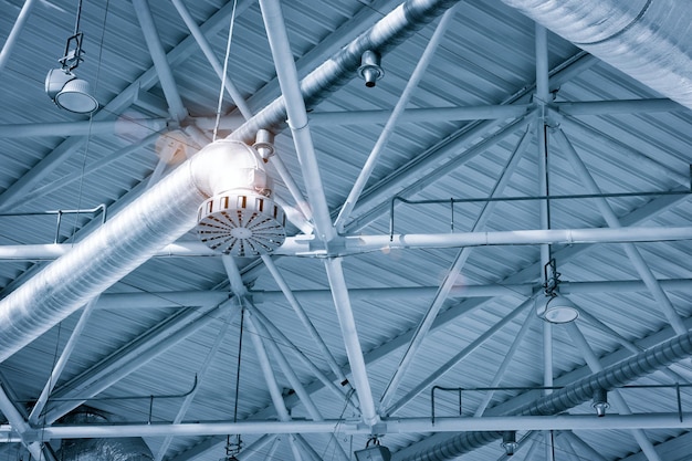 Ventilatiebuizen in zilver isolatiemateriaal hangend aan het plafond in nieuwbouw