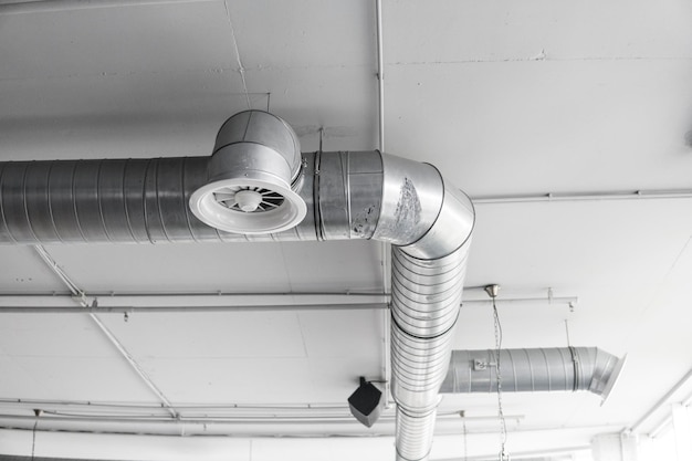 Ventilatiebuizen in zilver isolatiemateriaal hangend aan het plafond in nieuwbouw