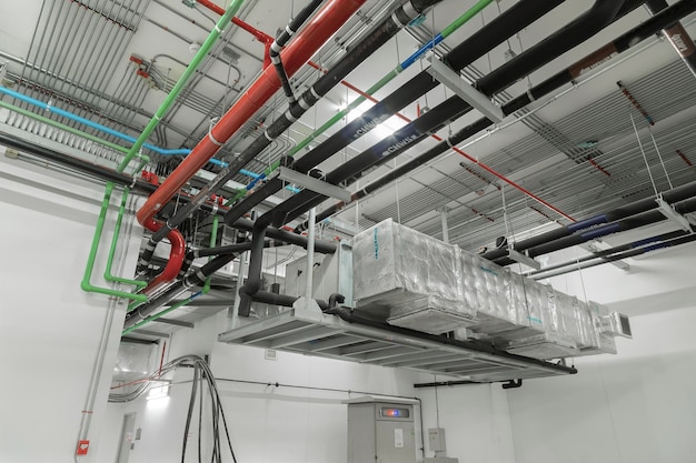 Ventilatiesysteem en leidingsystemen geïnstalleerd op industrieel gebouwplafond.