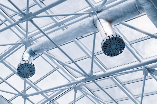 Ventilation pipes in abstract futuristic interior metal construction background in blue tones