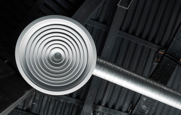 Photo ventilation pipes in silver insulation material hanging from the ceiling inside new building