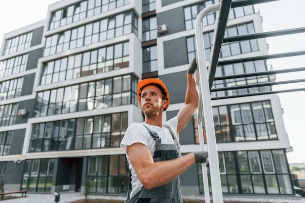 Ver weg kijken Jonge man die overdag in uniform aan het werk is in de bouw