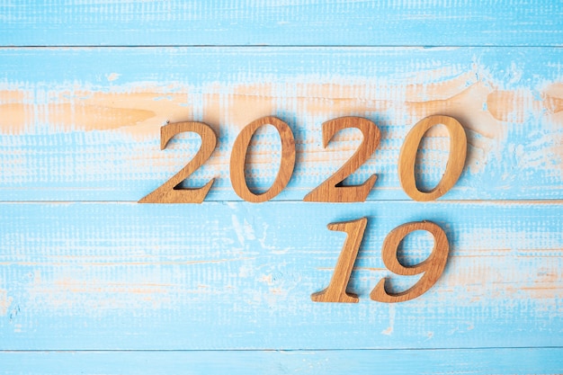 Verander 2019 naar 2020 nummer op houten achtergrond.