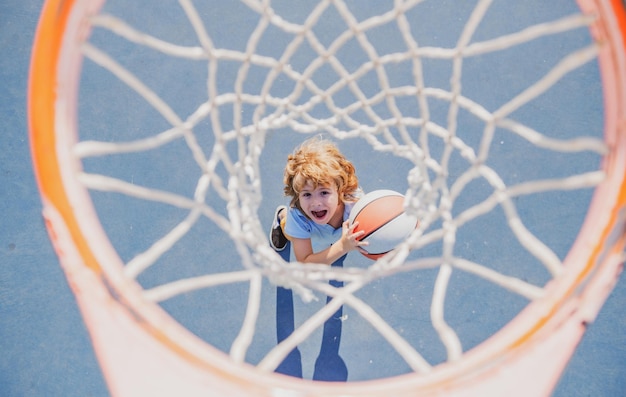 Verbaasd kind dat basketbal speelt met een bal met een blij gezicht