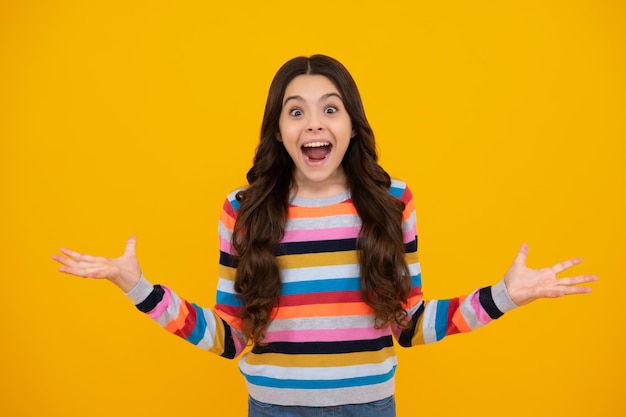 Verbaasd tiener portret van vrolijk kind meisje met opgeheven handen Kaukasische tiener schreeuwen geïsoleerd op geel Gelukkig kind uitroepen met vreugde en opwinding Opgewonden tiener meisje