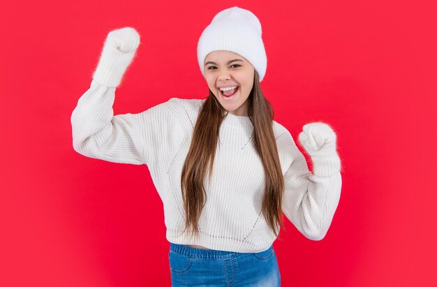 Verbaasd tienermeisje in warme wintergebreide trui en wanten in studio tiener wintermeisje