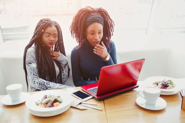 Verbaasde jonge vrouw zit aan tafel