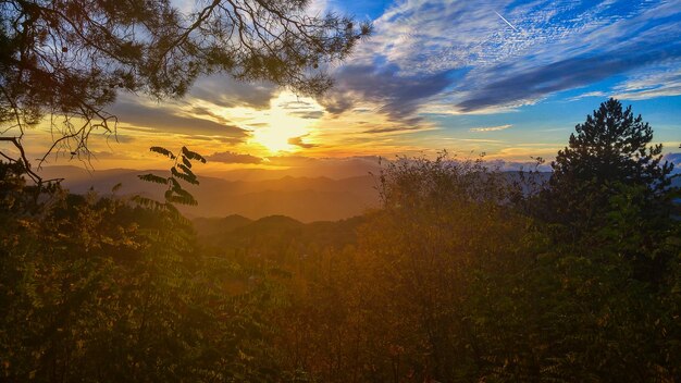Verbazingwekkend berglandschap met kleurrijke levendige zonsondergang aan de heldere hemel, natuurlijke buitenreisachtergrond