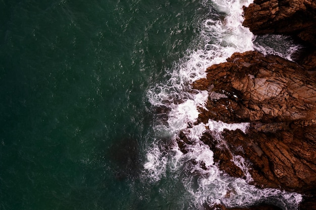 Verbazingwekkende bovenaanzicht prachtige kust Luchtfoto verpletterende golven op rotsen Donkere zee oppervlak kust rotsen kliffen achtergrond