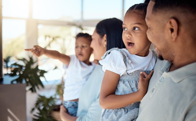 Verbindende liefde en ouders met kinderen in de woonkamer van hun huis praten met een glimlach Wauw vrijheid en vader die met zijn meisje spreekt met moeder en zoon blij met vrede in hun ouderlijk huis