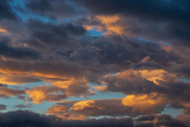 Verbluffende kleurrijke onweerswolken in blauwe lucht verlicht door zonnestralen bij zonsondergang tot weersveranderingen...