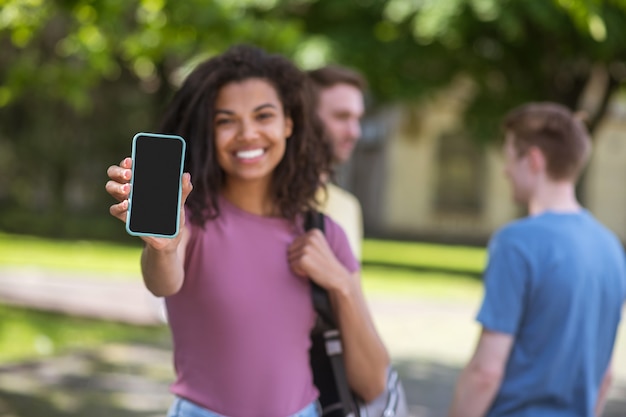 Verbonden. Leuke mulatta met een smartphone die mooi lacht