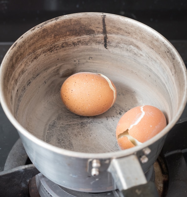 Verbrande hardgekookte eieren in pot, de eieren verbrand door te koken totdat het water opdroogde.