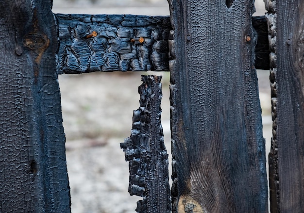 Verbrande schuttingplanken na een brand in een woonhuis