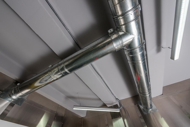 Verchroomde buizen van de ventilatiesysteemkamer met geforceerde trek en buizen onder het plafond