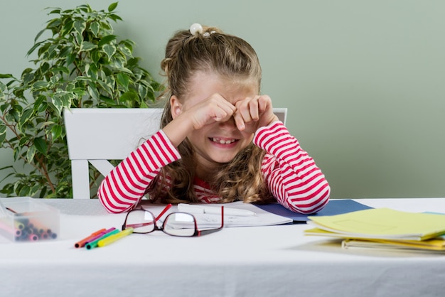 Verdrietig en moe schattig jong schoolmeisje.