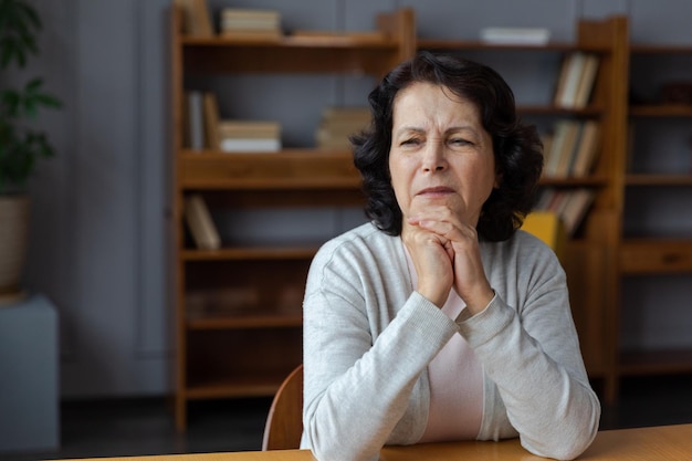 Verdrietig moe ziek ziek eenzaam teleurgesteld oudere oudere vrouw die alleen thuis zit Ongelukkige volwassen grootmoeder die verdriet ervaart relatieve dood slecht nieuws Benadrukt oudere dame die lijdt aan eenzaamheid