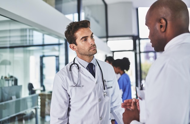 Verdubbel de doctoraatsexpertise Shot van twee artsen die een gesprek hebben in een ziekenhuis