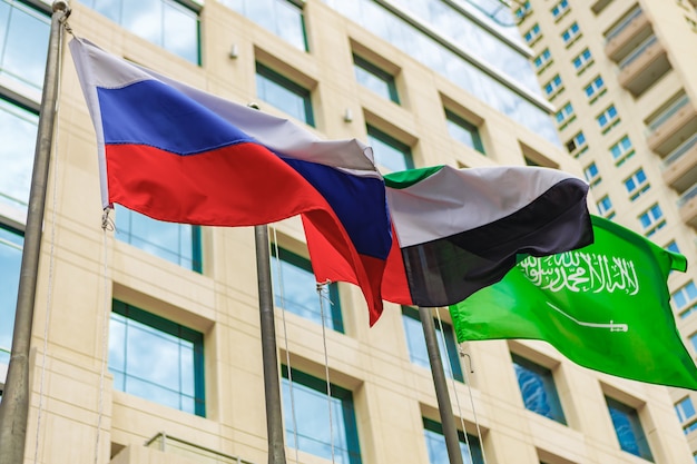 Verenigde Arabische Emiraten en Rusland vlag zwaaien tegen gebouw