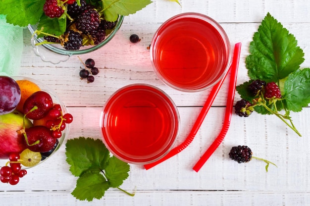 Verfrissend drankje compote van zomerbessen in glazen op een witte houten achtergrond Bovenaanzicht