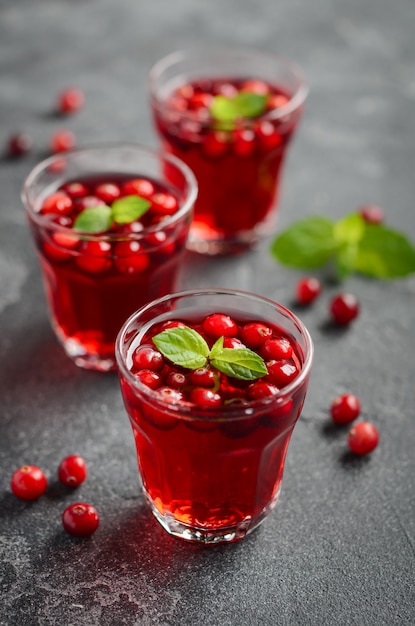 Verfrissende cocktail met cranberry en munt op donkere concrete achtergrond.