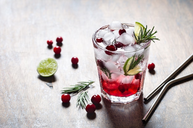 Verfrissende cranberrydrank met verse rozemarijn op rustieke achtergrond.