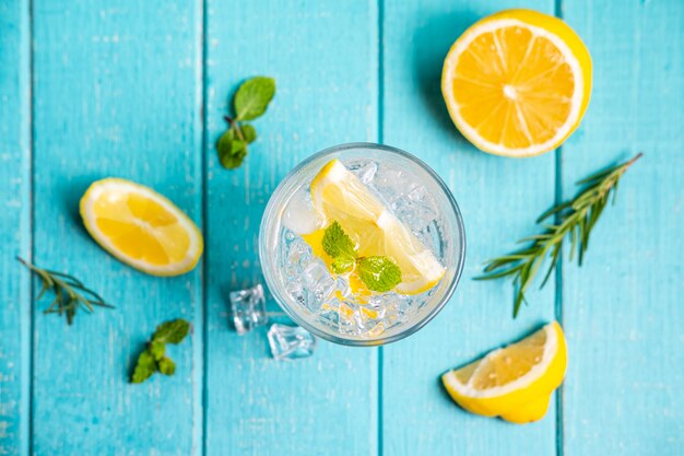 Verfrissende limonade in glas met citroen op houten tafel