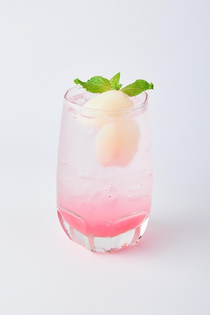 Foto verfrissende lychee soda met ijs bekleed met verse lychee en munt geïsoleerd op witte achtergrond