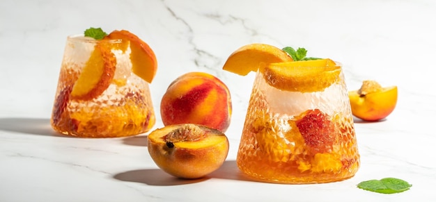 Verfrissende Peach Bourbon Smash Cocktail met ijsblokjes en munt in glas Lang bannerformaat