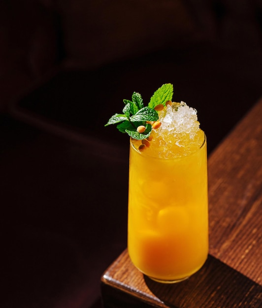 Verfrissende tropische cocktail versierd met munt en dennennoten