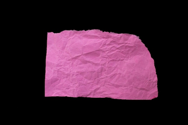 Verfrommeld gescheurd roze papieren stuk geïsoleerd op zwarte achtergrond