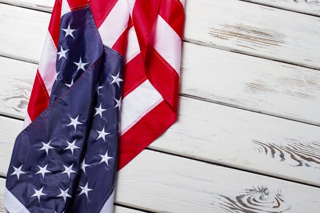 Verfrommeld vlag van de VS. USA vlag op houten achtergrond. Banner die op witte plank legt. Groeten uit het land van kansen.