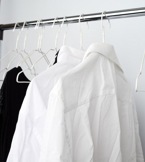 Verfrommelde blanke shirts hangen aan een metalen hanger